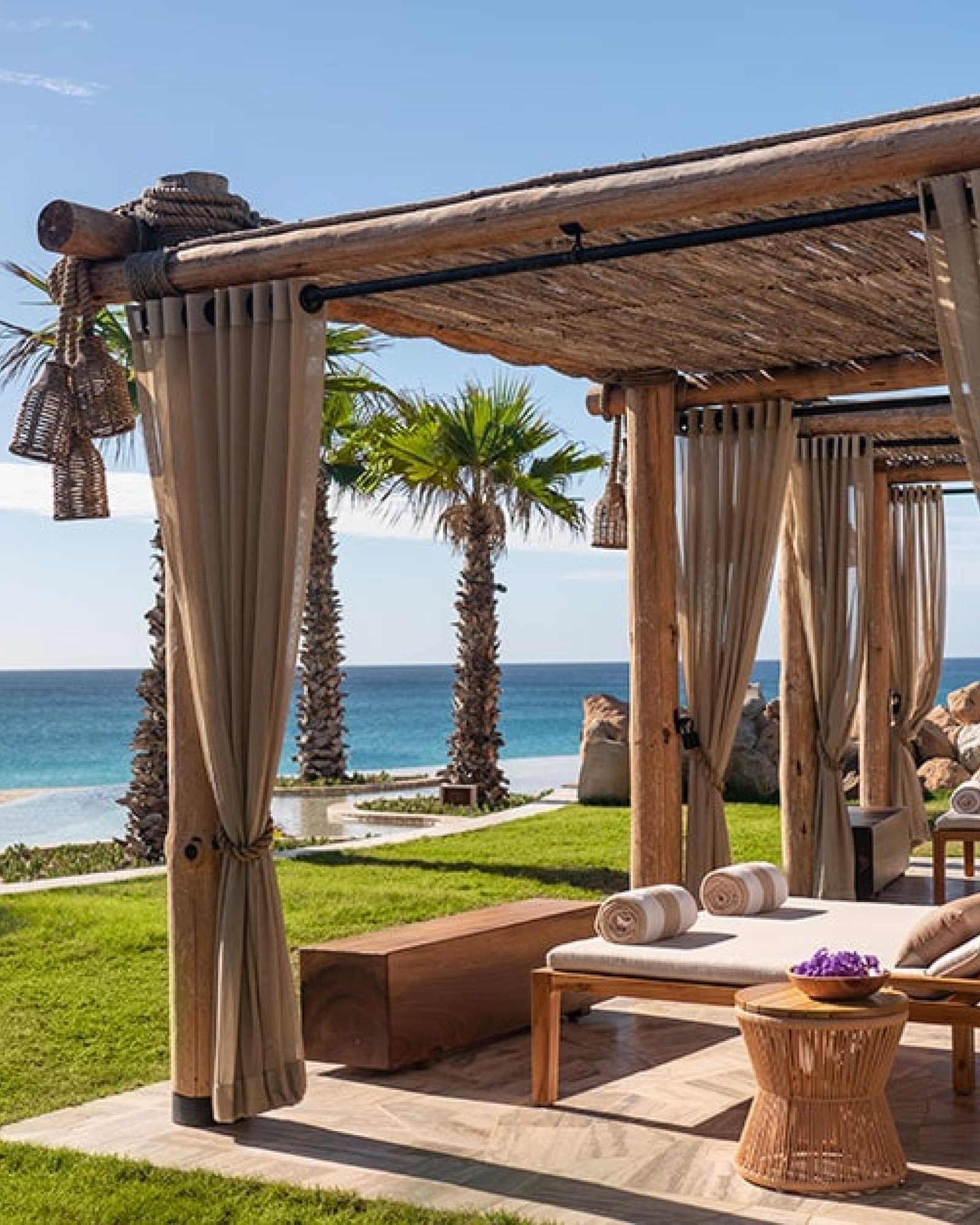 A curtained cabana on the lawn above the beach